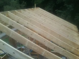 New roof rafters set over an addition before sheathing in Shiner