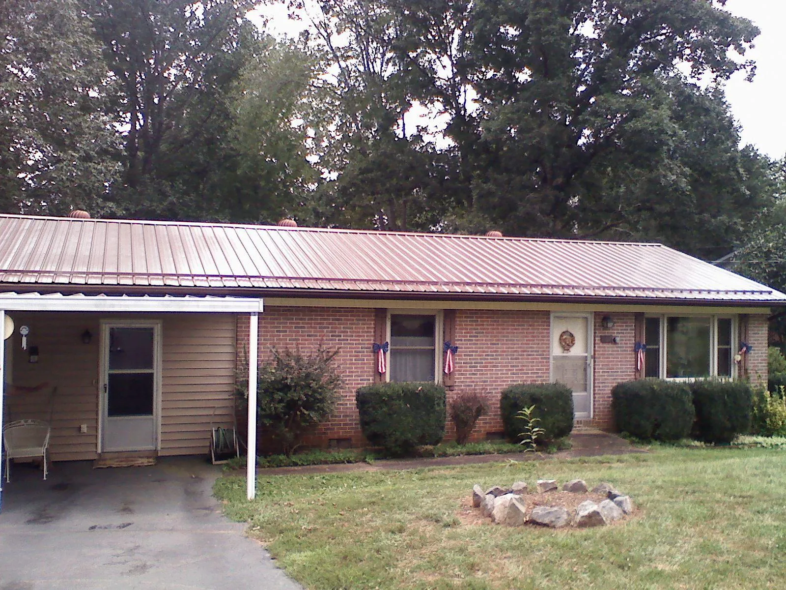 Bronze metal roof and carport on a brick ranch home — Roof Repair work by our crew in Shiner
