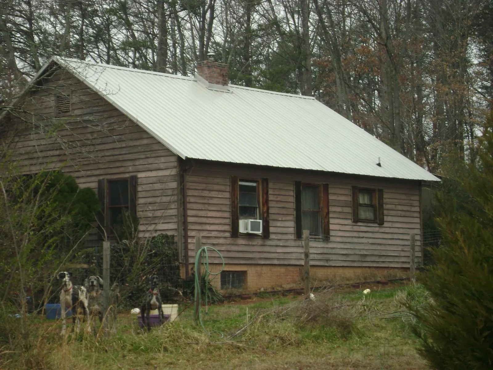 White metal roof on an old wood sided farmhouse, from a Metal Roof Installation job in Shiner